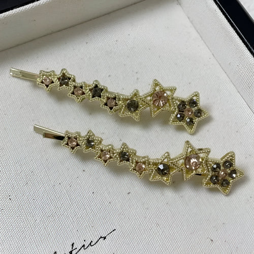 Gold electroplated alloy barrette with five-pointed star rhinestone design and broken clip construction