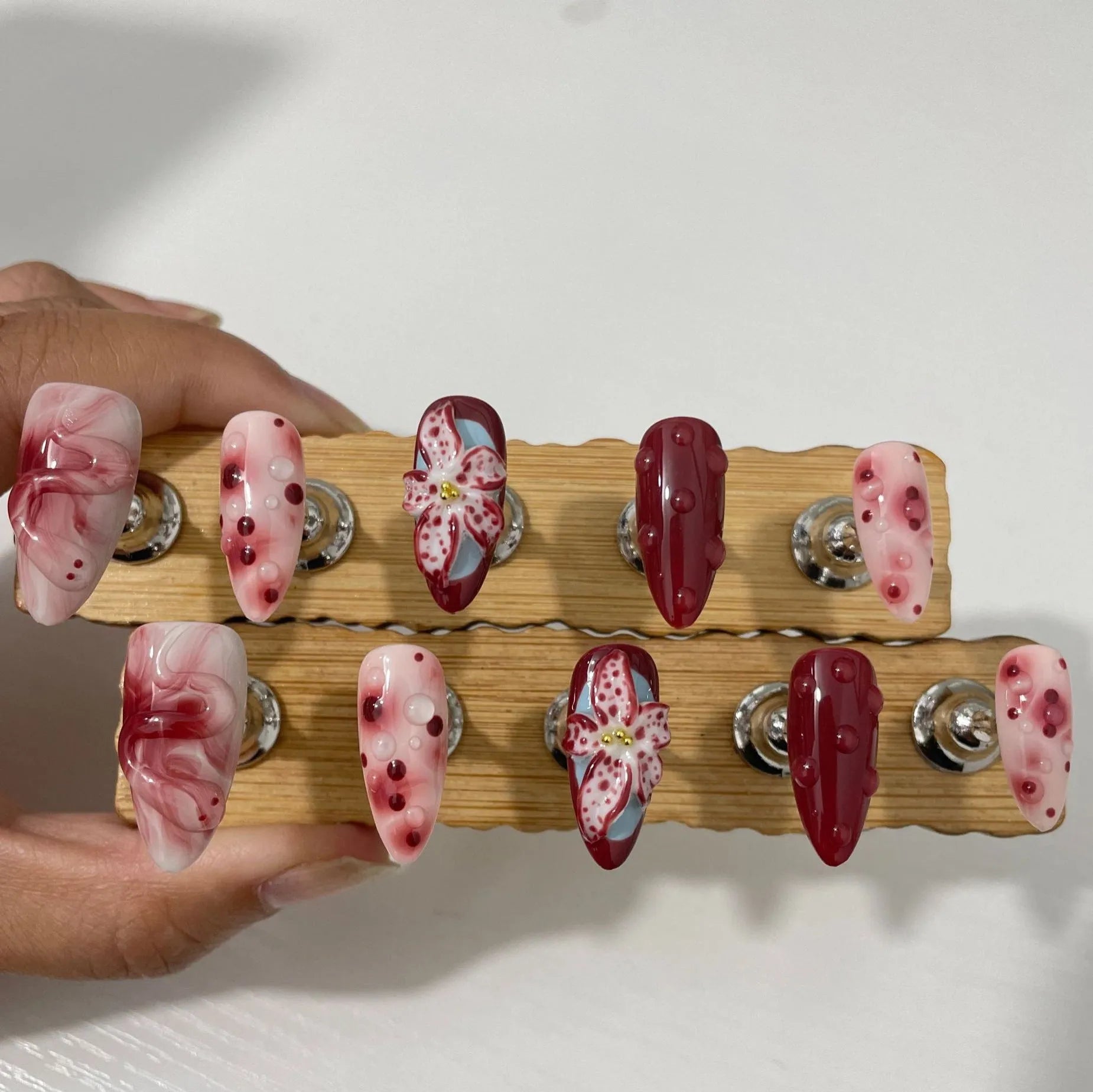 Hand-painted 3D carved artificial nails with floral designs on almond-shaped tips