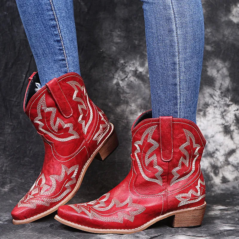 Women's blue embroidered cowboy boots with a wedge heel and pointed toe on a white background.