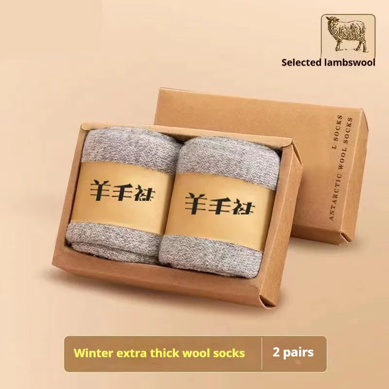 Two pairs of thick grey winter wool socks with a merino midsole next to a storage box