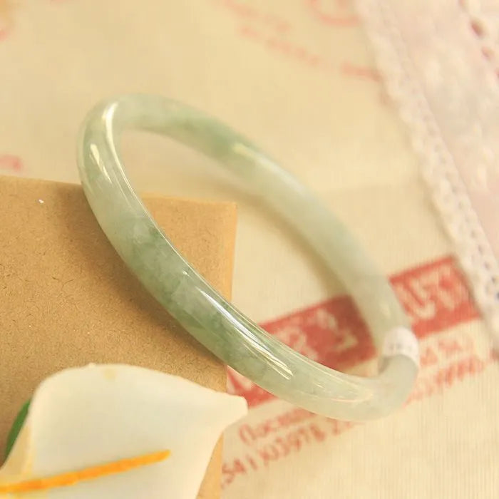 Green jade waxy geometric bead bracelet with adjustable cord on a plain background.