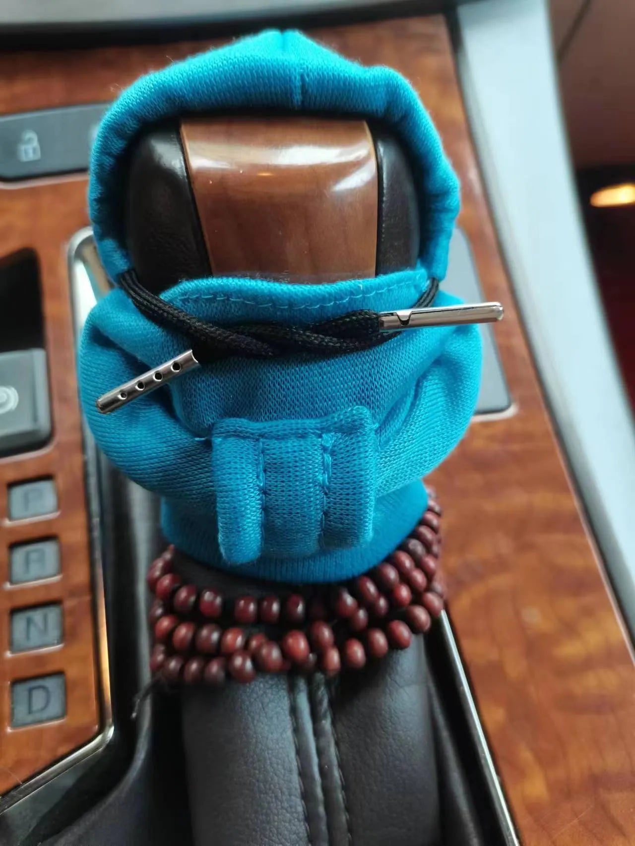 Soft Dutch velvet car gear handle cover in multiple colours on a gear stick.