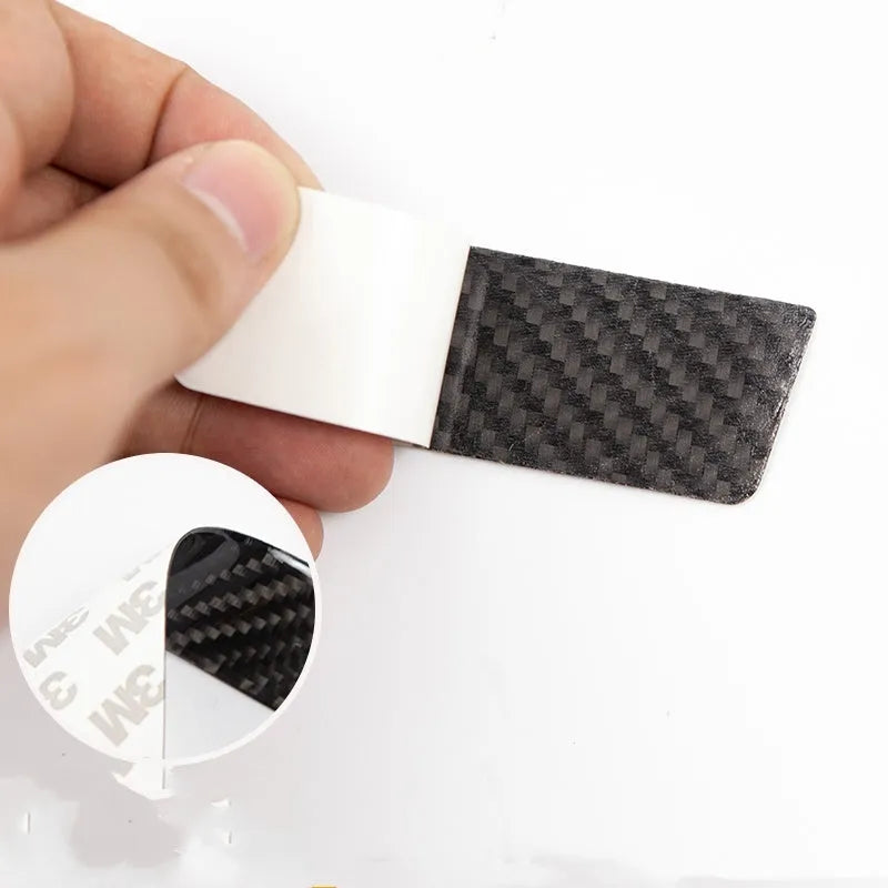 Four carbon fibre adhesive door handle protection stickers for Tesla Model S interior.