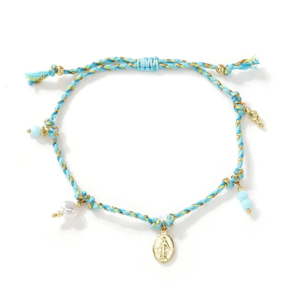 Close-up of a woman's hand-woven colourful braided rope bracelet with an adjustable strap tag.