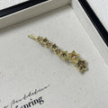 Gold electroplated alloy barrette with five-pointed star rhinestone design and broken clip construction