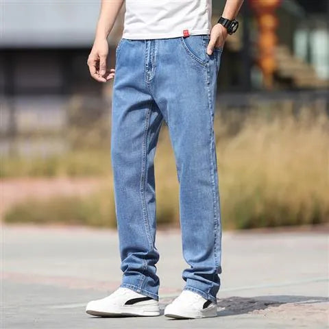 Man wearing smoky grey straight leg men's jeans with a low waist and zip fly.