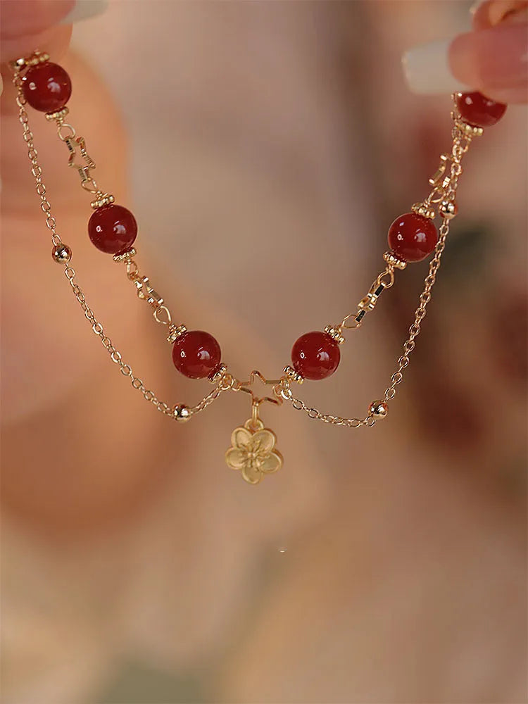 Red agate double layer bracelet for women with carved peach blossom and flower designs.