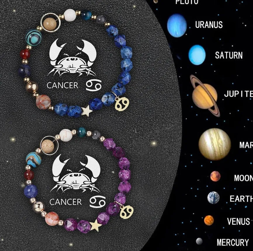 Set of two natural stone beaded bracelets with metal zodiac charms on a dark background.