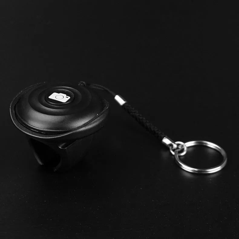 Black Bluetooth remote control selfie shutter with compact button design on PC material casing