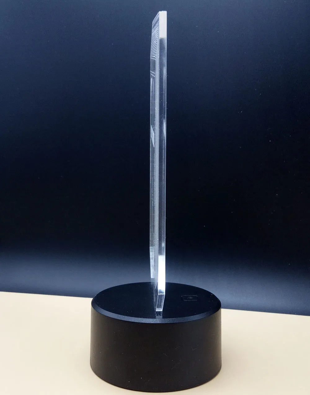 3D rose design acrylic night light with ABS base on a table, showing multi-coloured LED illumination.