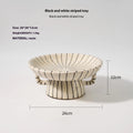 Black and white striped resin fruit plate on a table for dessert serving.