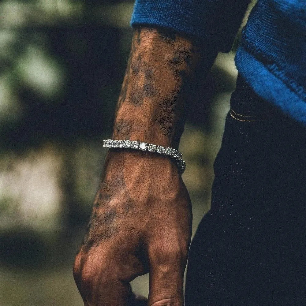 Men's silver geometric hip hop bracelet with rhinestone chain links and dangling zirconia tennis charms on a white background.