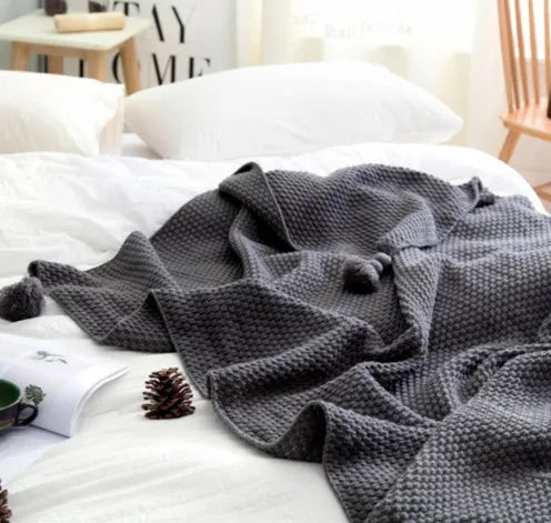 Nordic fringed knit ball acrylic blanket in beige colour, laid flat showing 130x170cm size and fringe detail