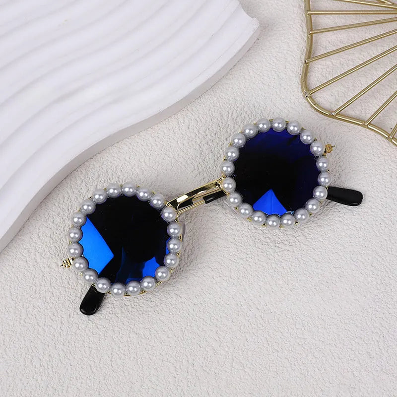 Pearl-rimmed round sunglasses for a cat or dog on a festive background.