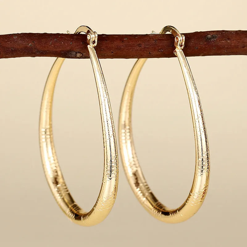 Women's geometric drop earrings with clip-on fastening in copper with ring and line design elements