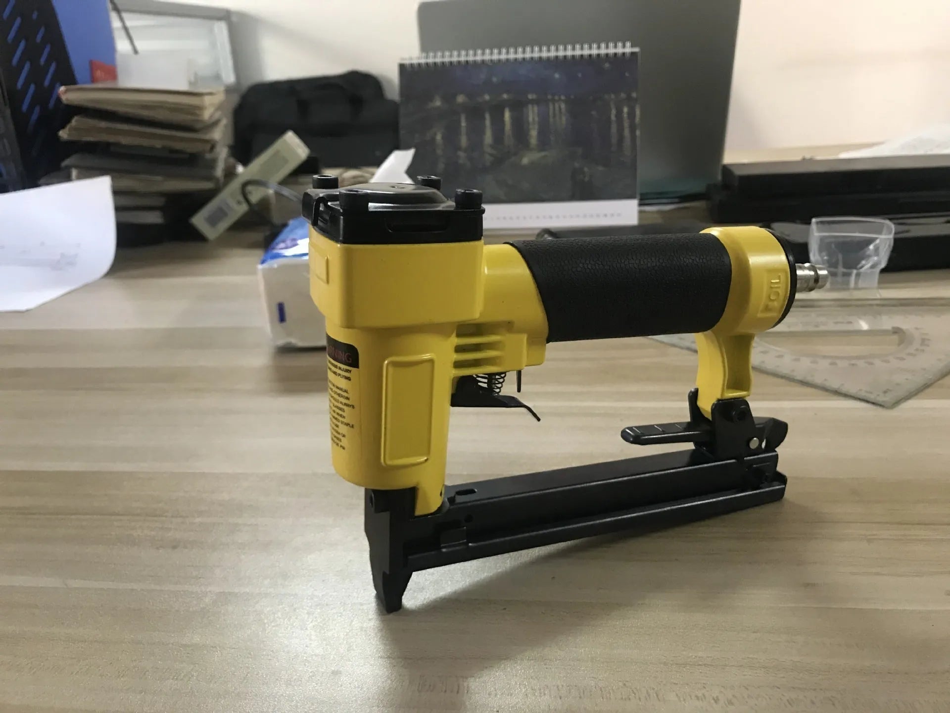 Blue pneumatic strip nail gun with American connector for decoration and upholstery work