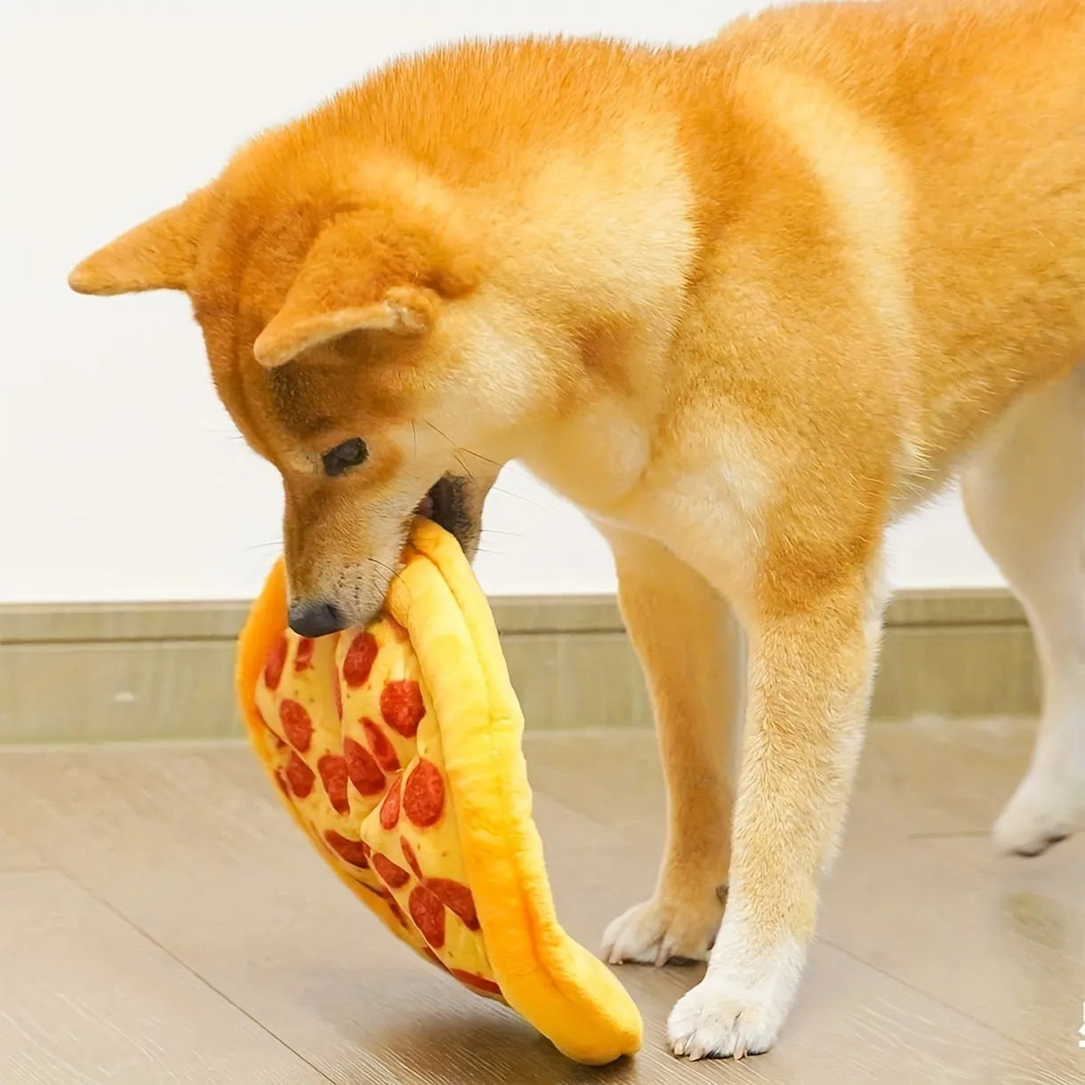 Yellow pizza slice shaped rubber dog chew toy with textured ridges and a squeaker.