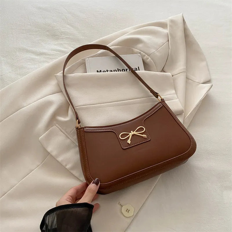 Western style PU leather shoulder bag with bow detail in horizontal square shape.