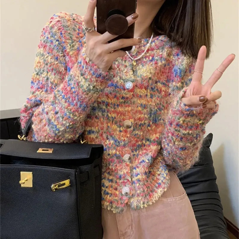 Pink and green retro style slim-fit knitted cardigan sweater on a hanger.