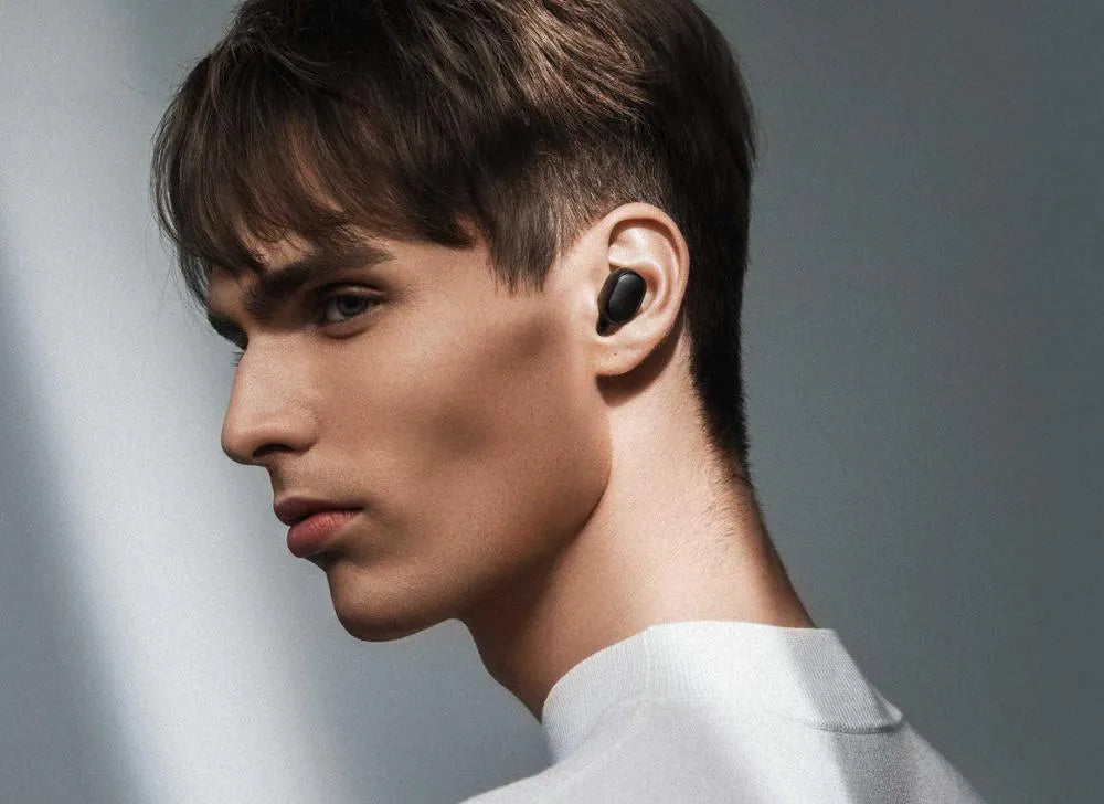 Redmi AirDots Black true wireless earbuds and their white charging case on a table