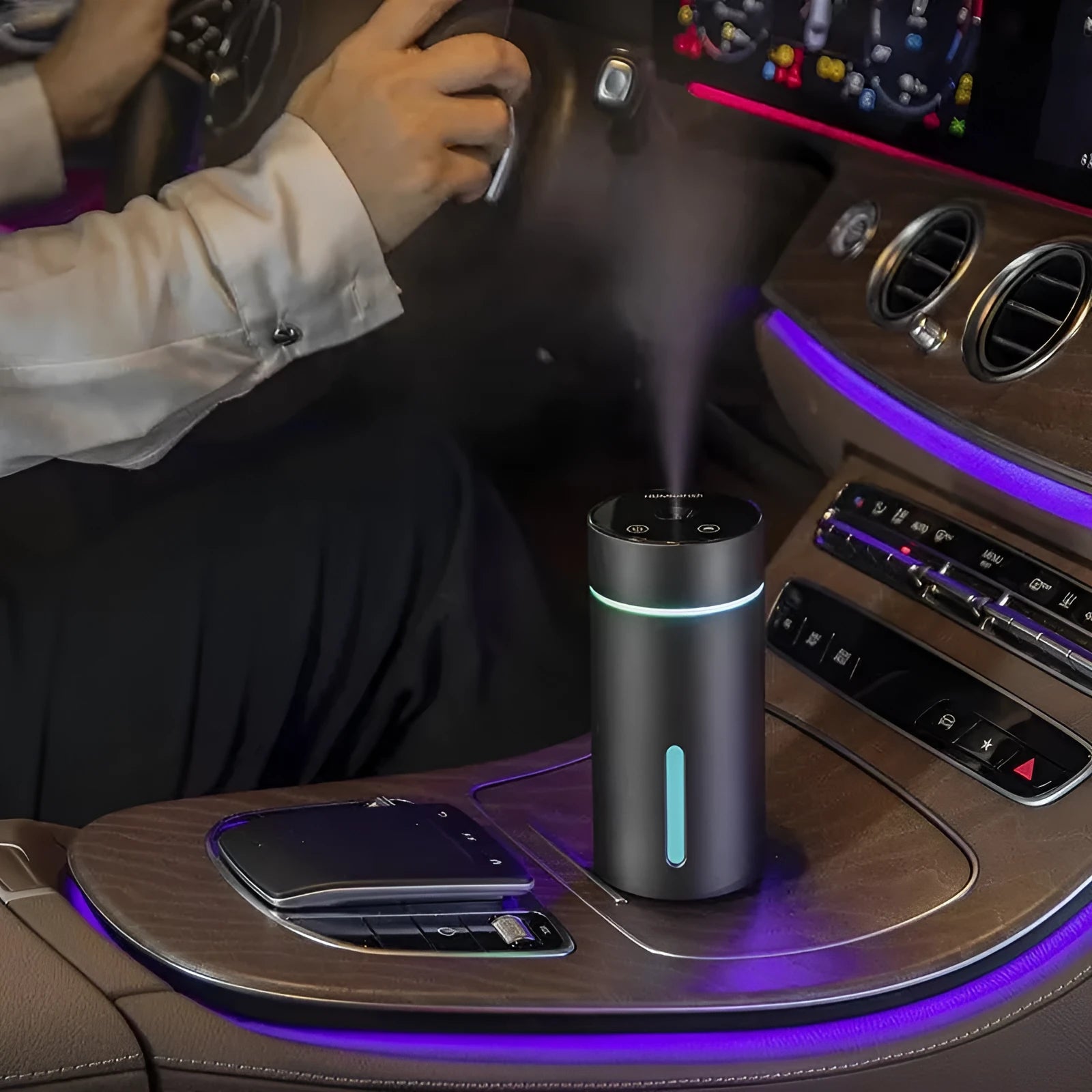 Black aluminium car humidifier and essential oil diffuser with colourful night light on, 66mm wide.