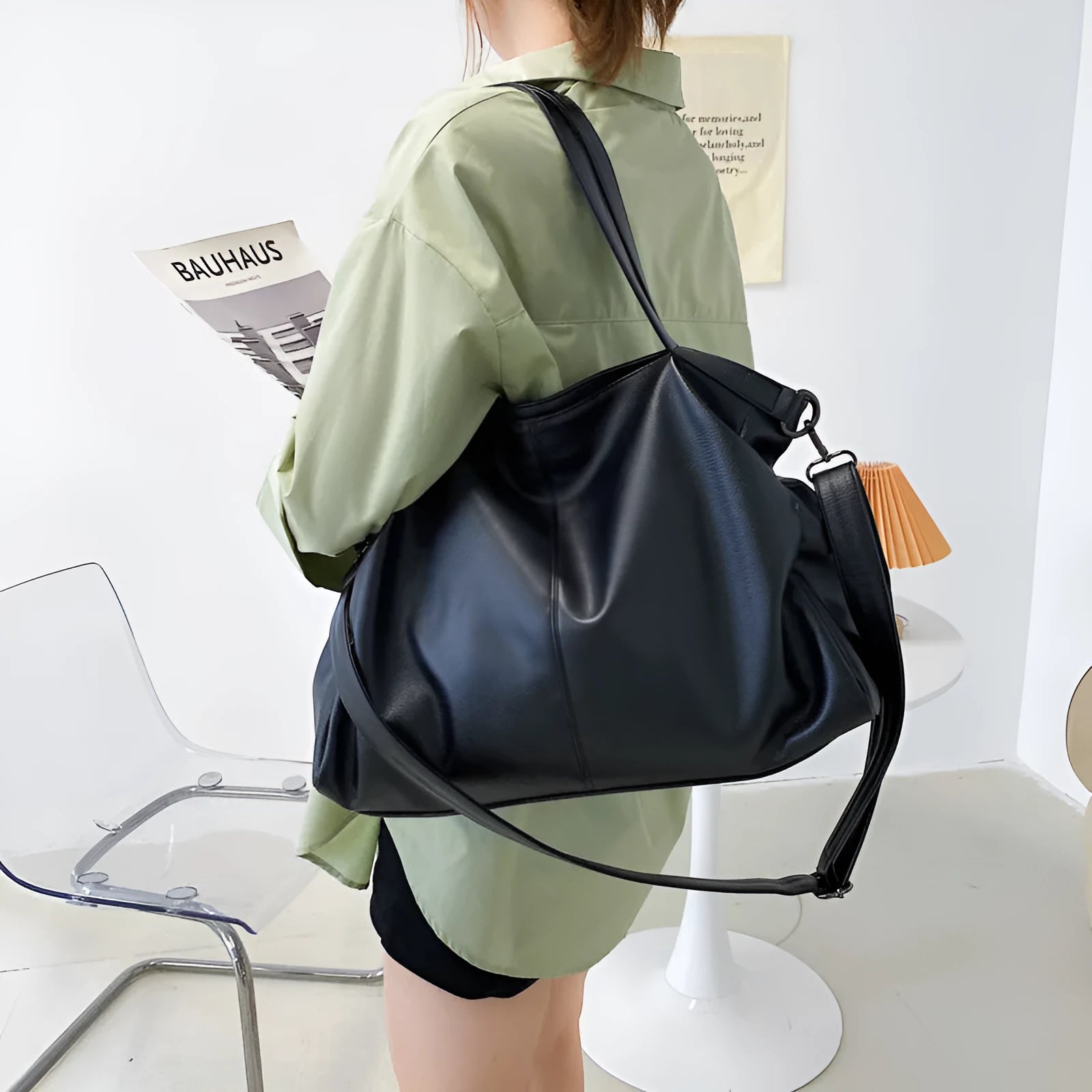 Large soft black PU messenger bag with car suture detail, shown with zip open revealing organiser pockets.