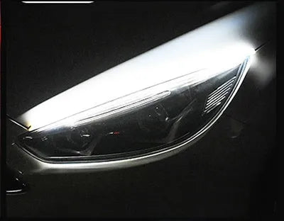 Universal car LED daytime running light strip with flowing turn signal on a vehicle headlight.