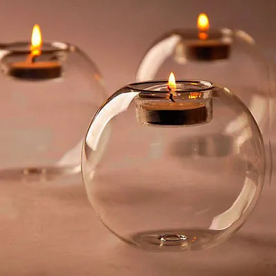 Handmade clear round hollow glass candle holder in three size options on wooden table