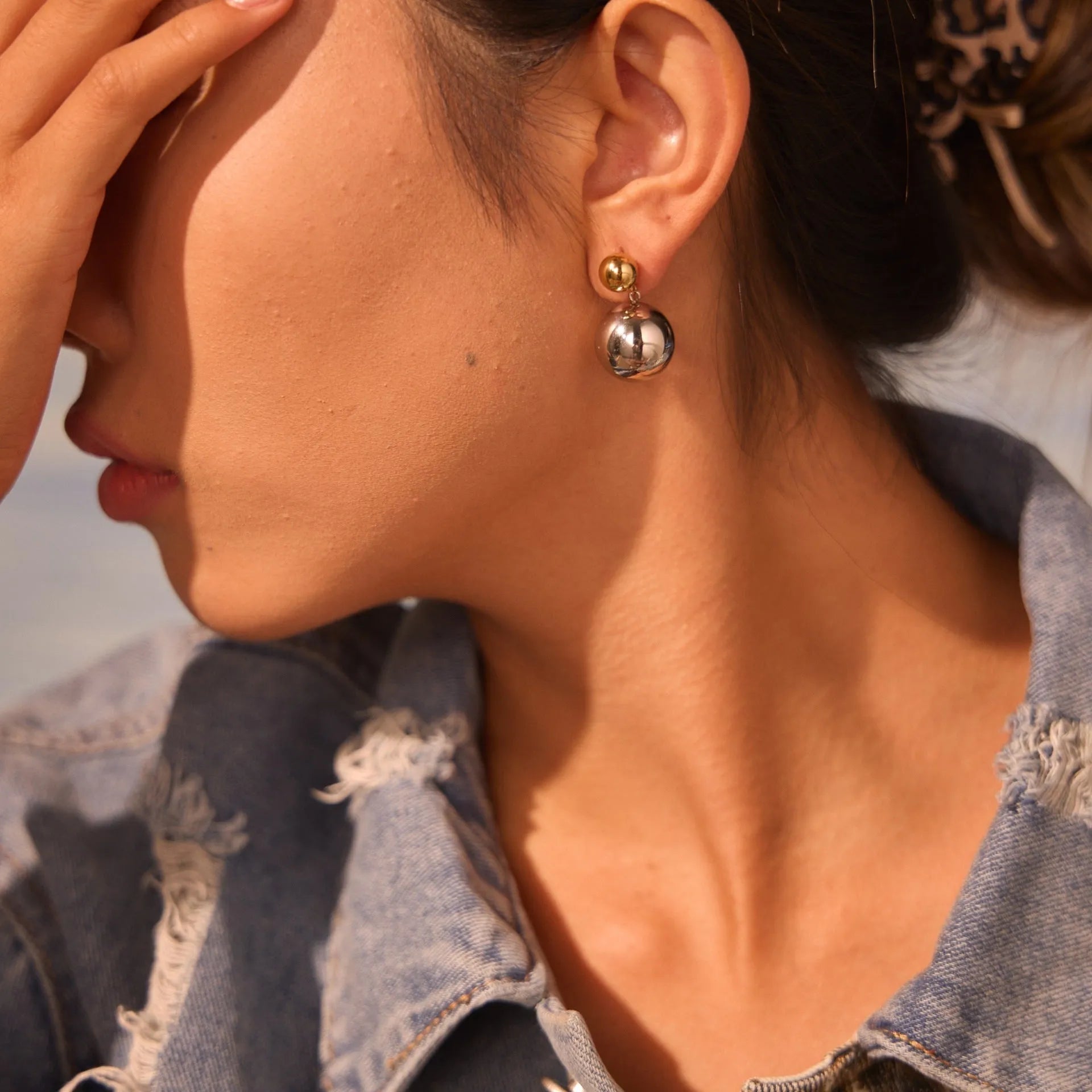 A pair of stainless steel stud earrings with 18K gold electroplated colour-block finish and round bead geometry design.