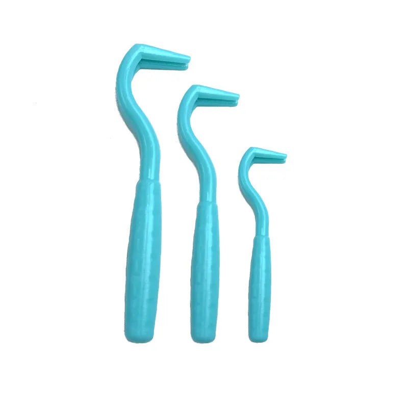 Set of three coloured plastic tick hook removers for dogs on a white background.