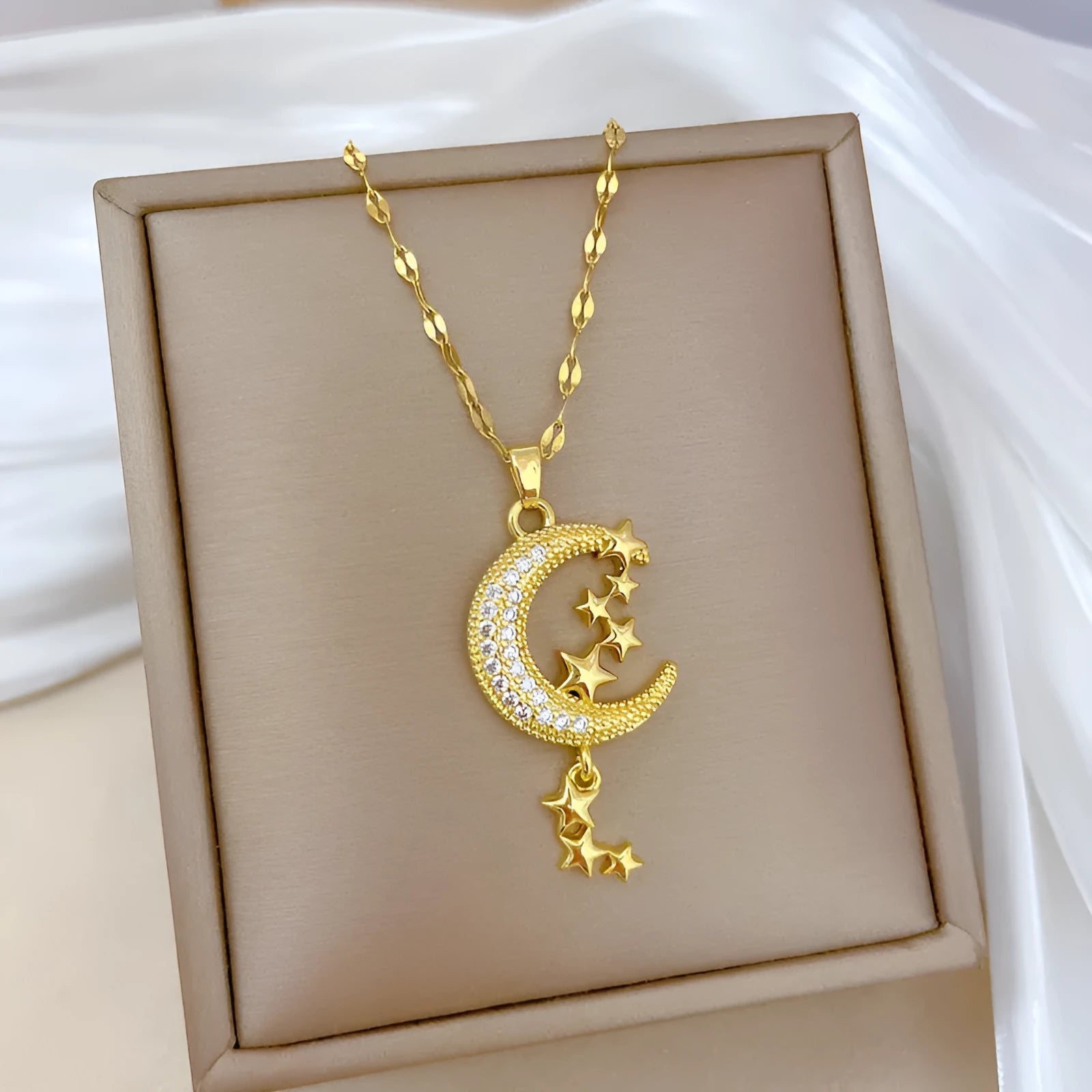 Moon-themed necklace with geometric copper pendant featuring tassel and diamond details on stainless steel chain