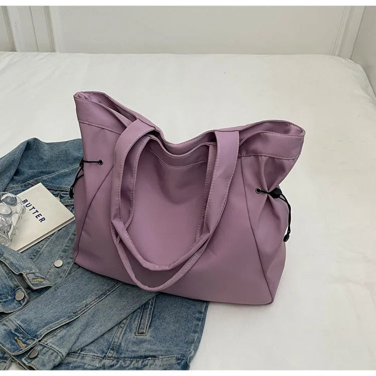 Soft oxford cloth folding commuter tote bag in street style, shown in black, grey, brown, and purple colours.