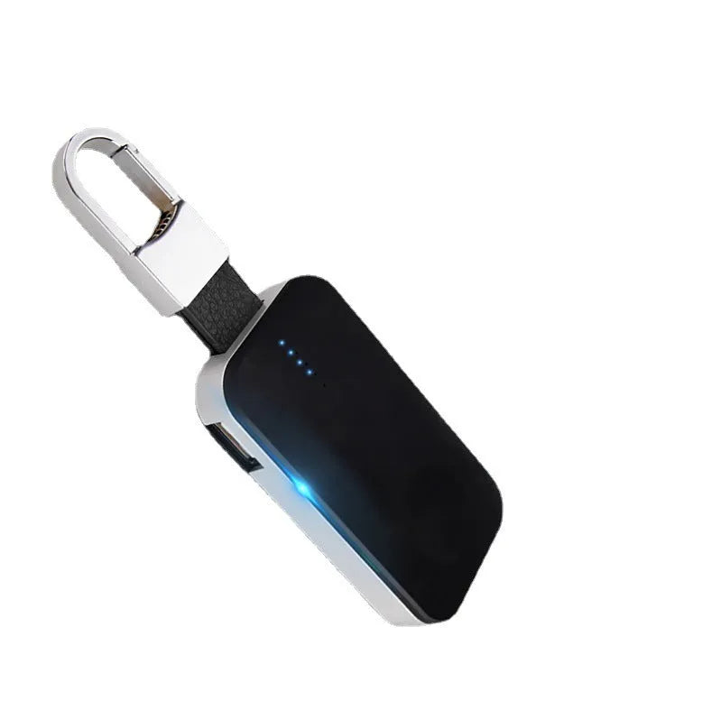 Black Apple Watch portable power bank keychain charger with USB port shown next to an Apple Watch.