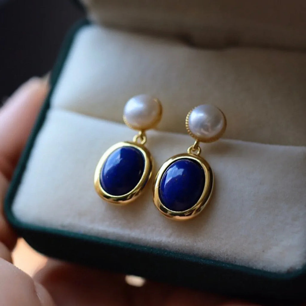 A pair of simple stud earrings with a blue lapis lazuli pearl set in sterling silver.