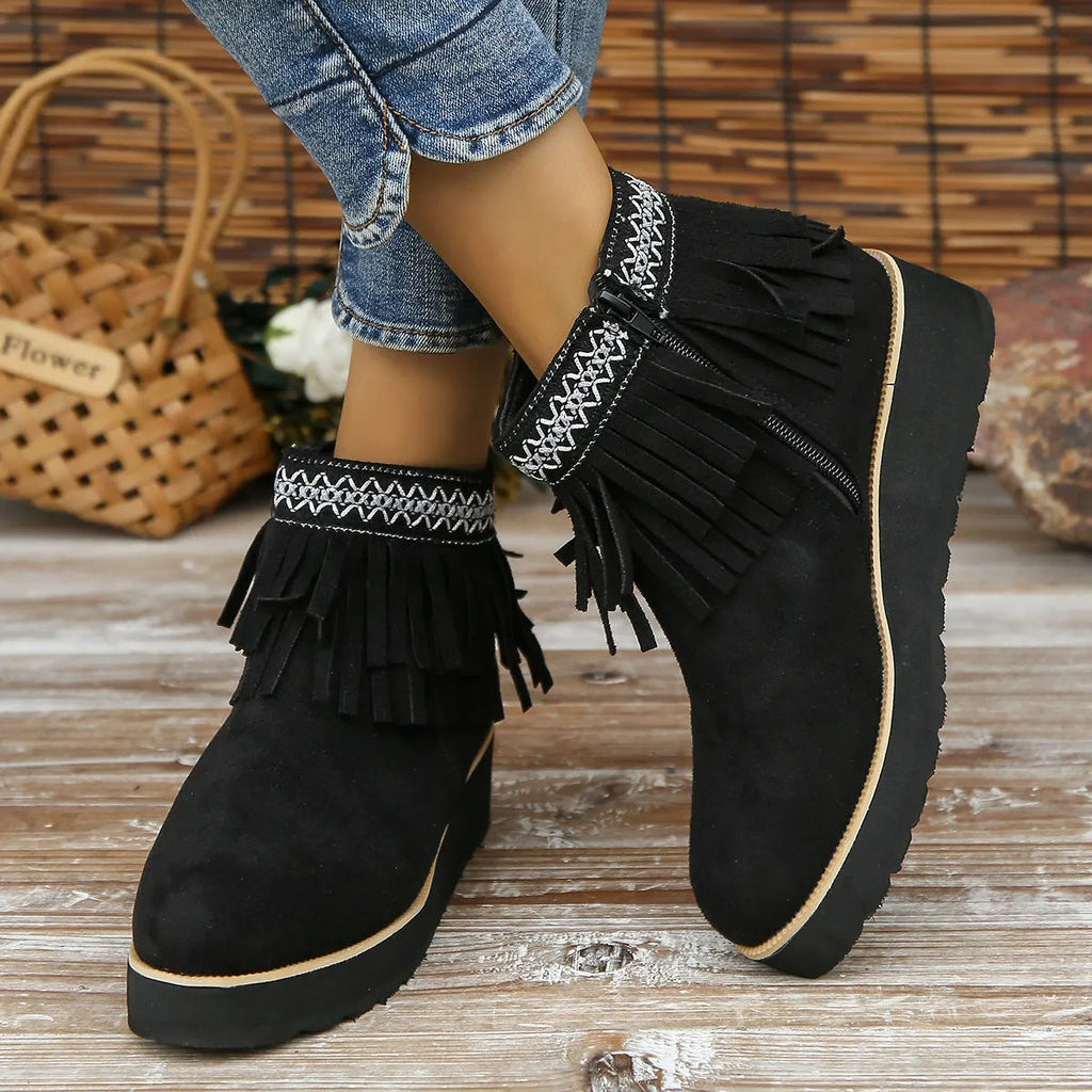 Women's dark brown suede wedge bootie with thick sole, side zipper, and tassel detail.