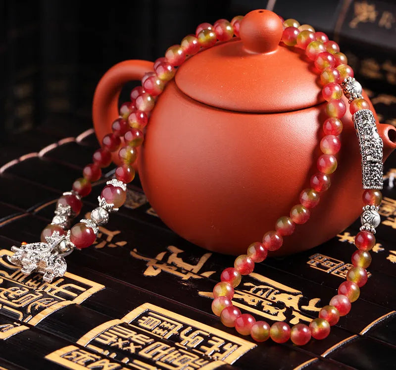 Handmade bracelet with a watermelon crystal elephant bead on a Chinese knot cord.