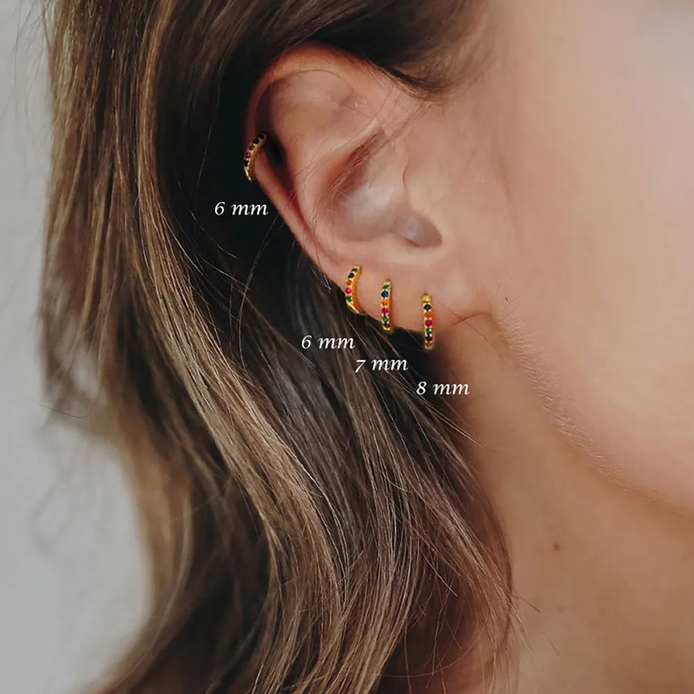 Gold, rose gold, and silver coloured circle-shaped zircon stud earrings on a white background.