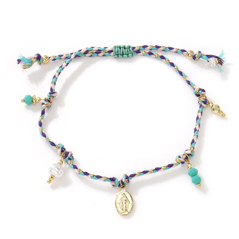 Close-up of a woman's hand-woven colourful braided rope bracelet with an adjustable strap tag.