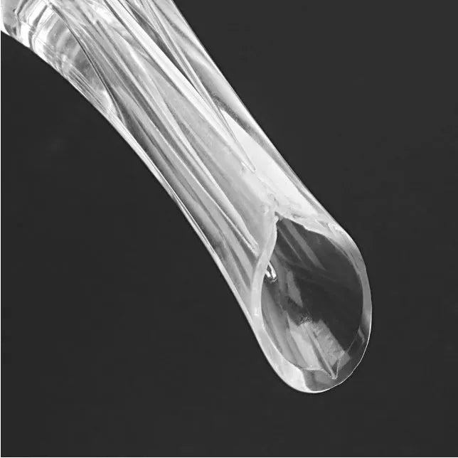 Compact clear acrylic wine aerator with a stainless steel filter insert on a wooden table.