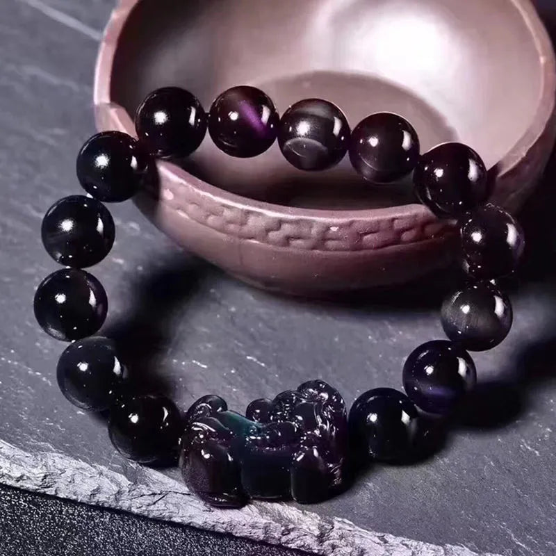 Polished natural ice colour Eye Obsidian crystal beads on an elasticated bracelet cord.