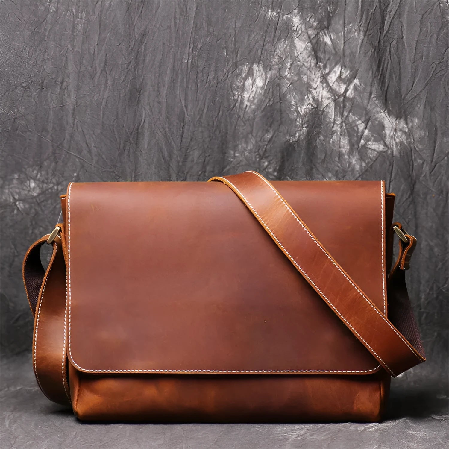 Brown vintage leather men's messenger bag with a flap opening and an adjustable shoulder strap.