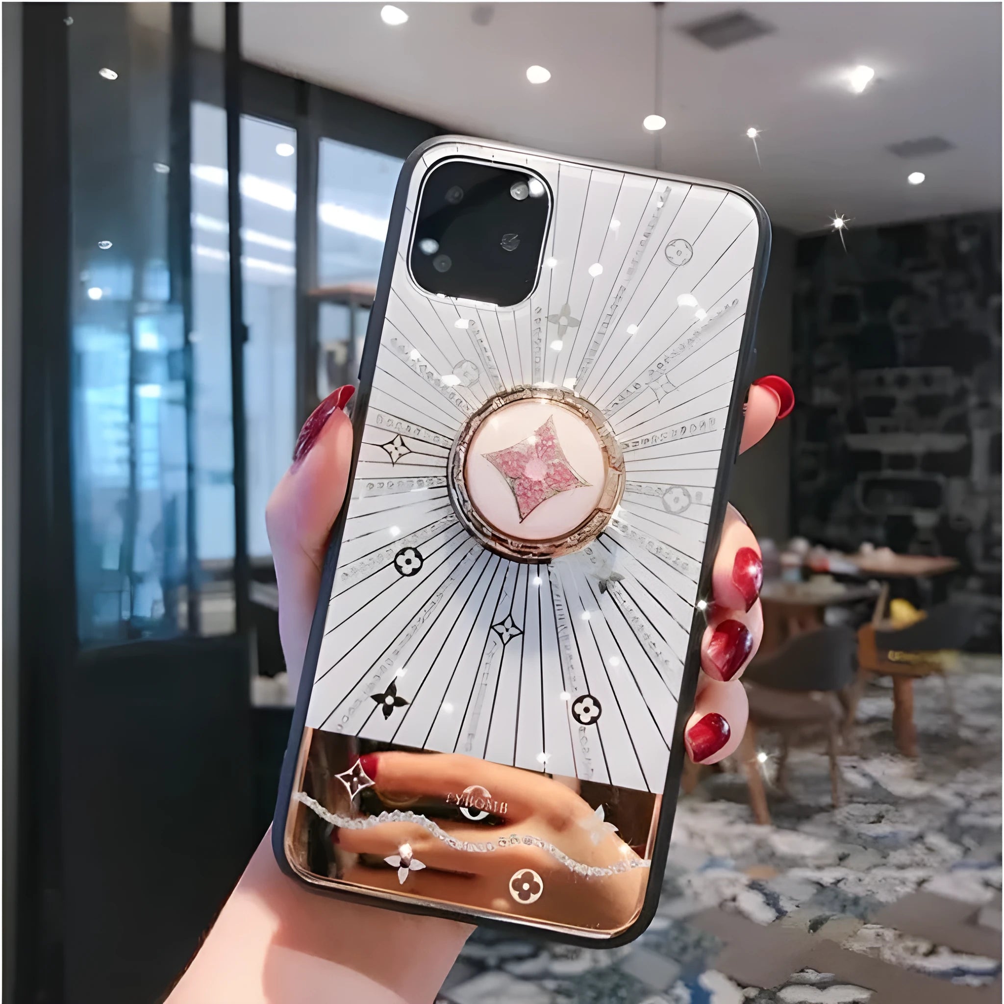 Gold-tone phone stand with diamond crystals holding iPhone and rings