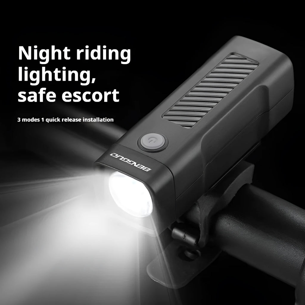A black USB-rechargeable bicycle headlight mounted on a handlebar with a quick-release strap.