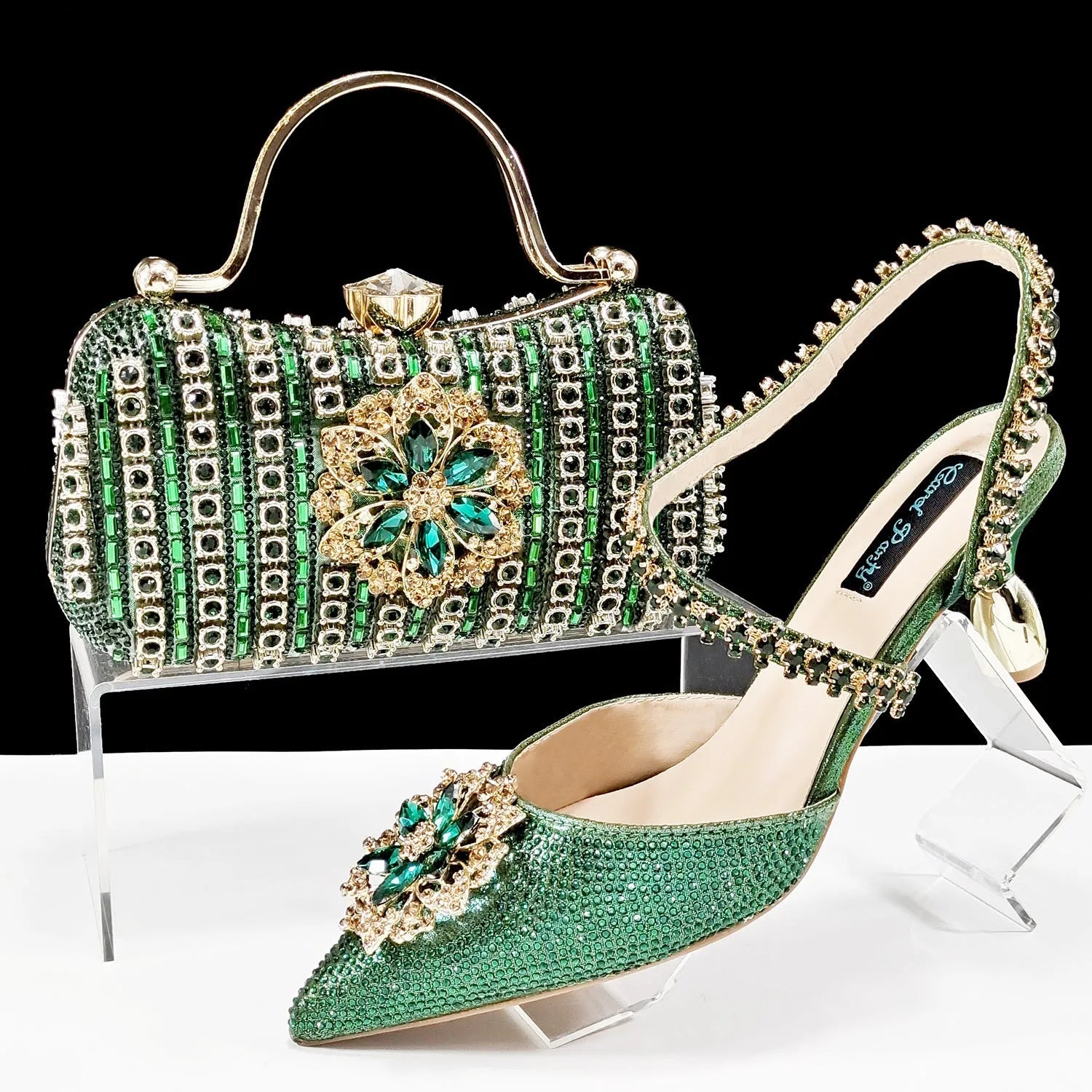 Women's black high heel sandals with ankle chain, floral rhinestone detail, and matching hard clutch bag