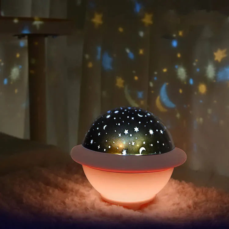 Green UFO-shaped starry sky projection night light on a table, showing rotating planet display on wall.