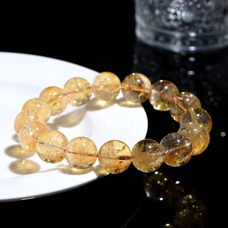 A natural yellow citrine beaded bracelet with geometric stones on a wrist, showing single circle design.