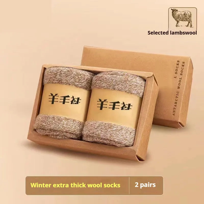 Two pairs of thick grey winter wool socks with a merino midsole next to a storage box