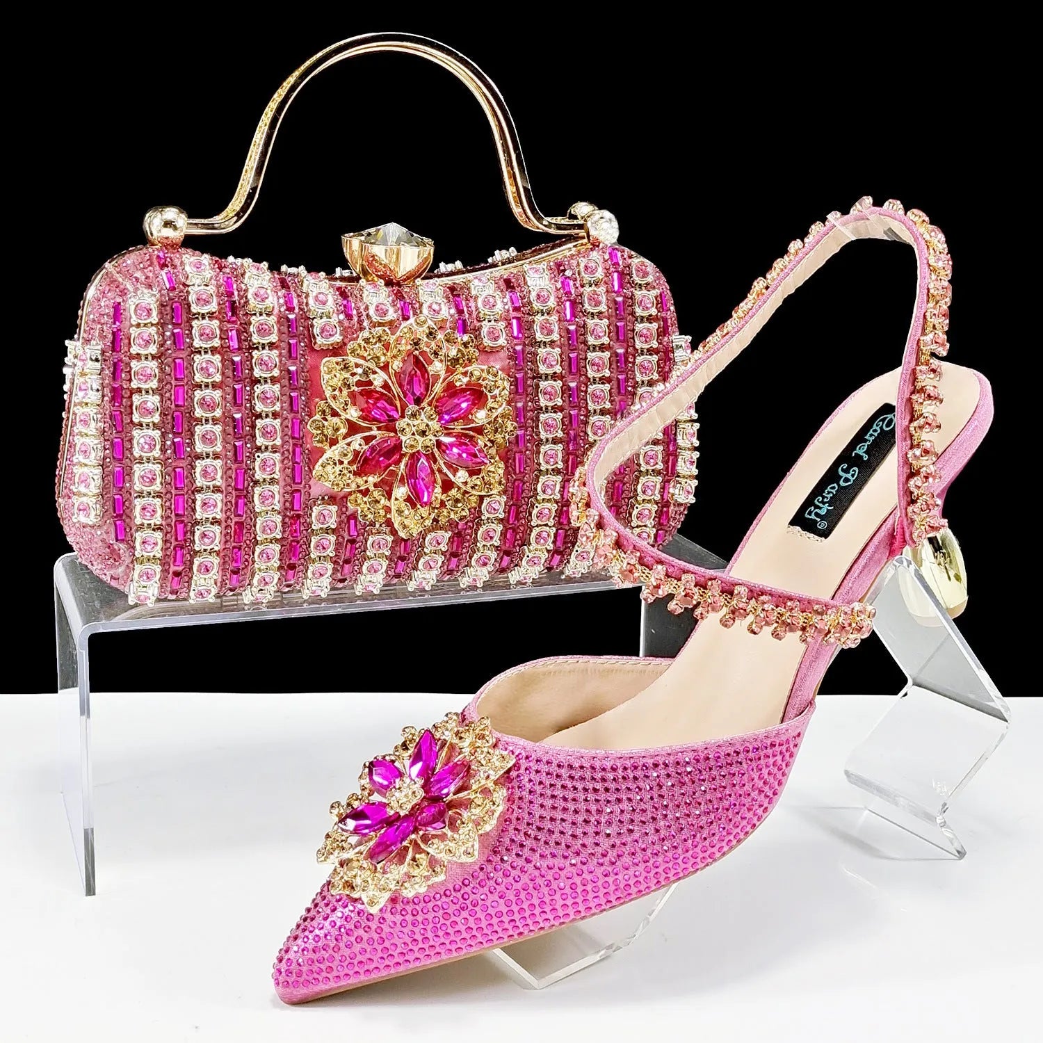 Women's black high heel sandals with ankle chain, floral rhinestone detail, and matching hard clutch bag