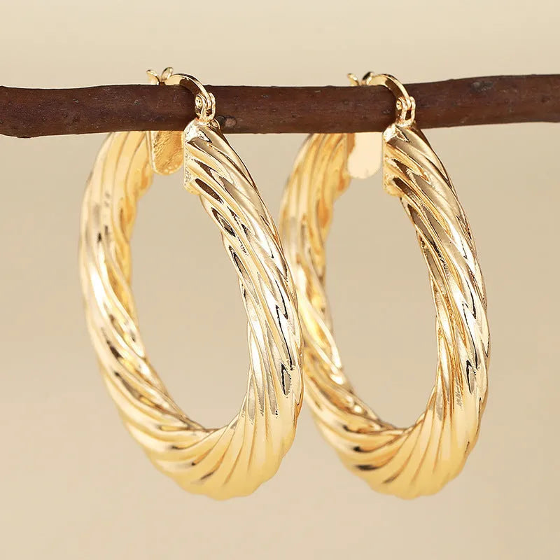 Women's geometric drop earrings with clip-on fastening in copper with ring and line design elements