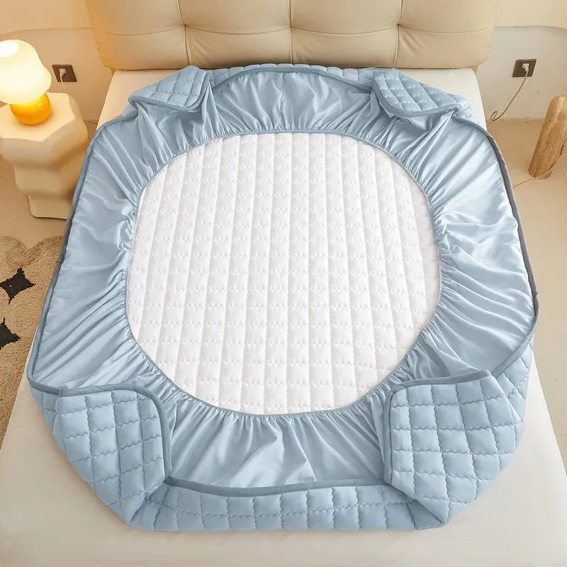 Blue washed cotton waterproof fitted sheet with elasticated corners shown on mattress